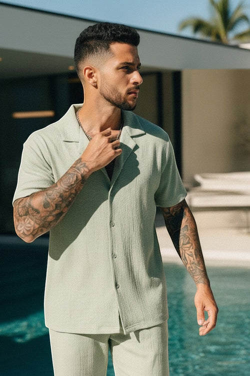 Ergoflex light green polyester short-sleeve button-up shirt and elastic waist shorts set for men.